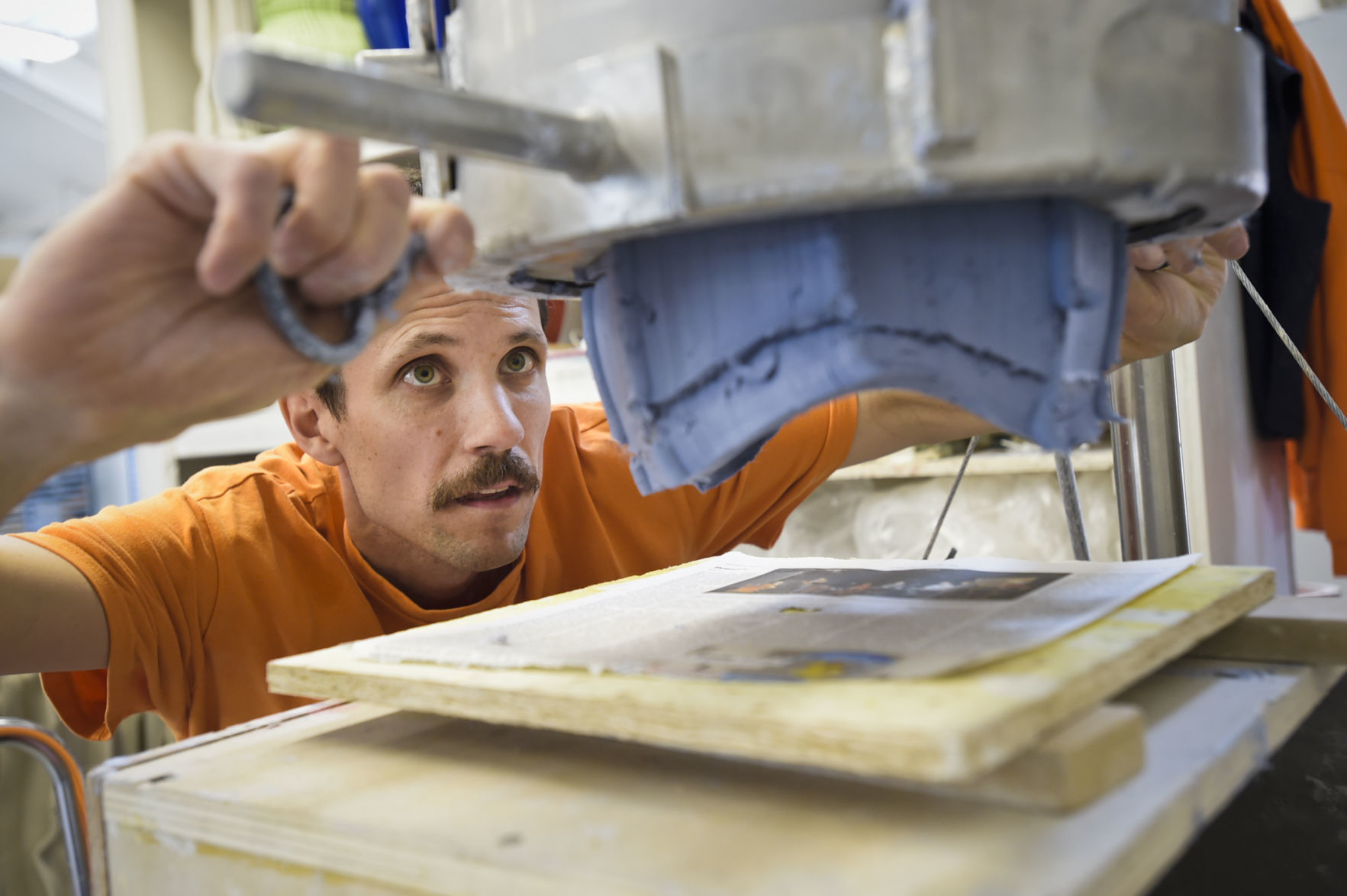 Archie Bray resident Anton Alvarez pulls a piece of clay away from a clay extruding machine